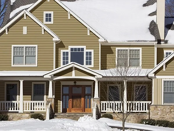 Home with brown insulated siding in snowy region